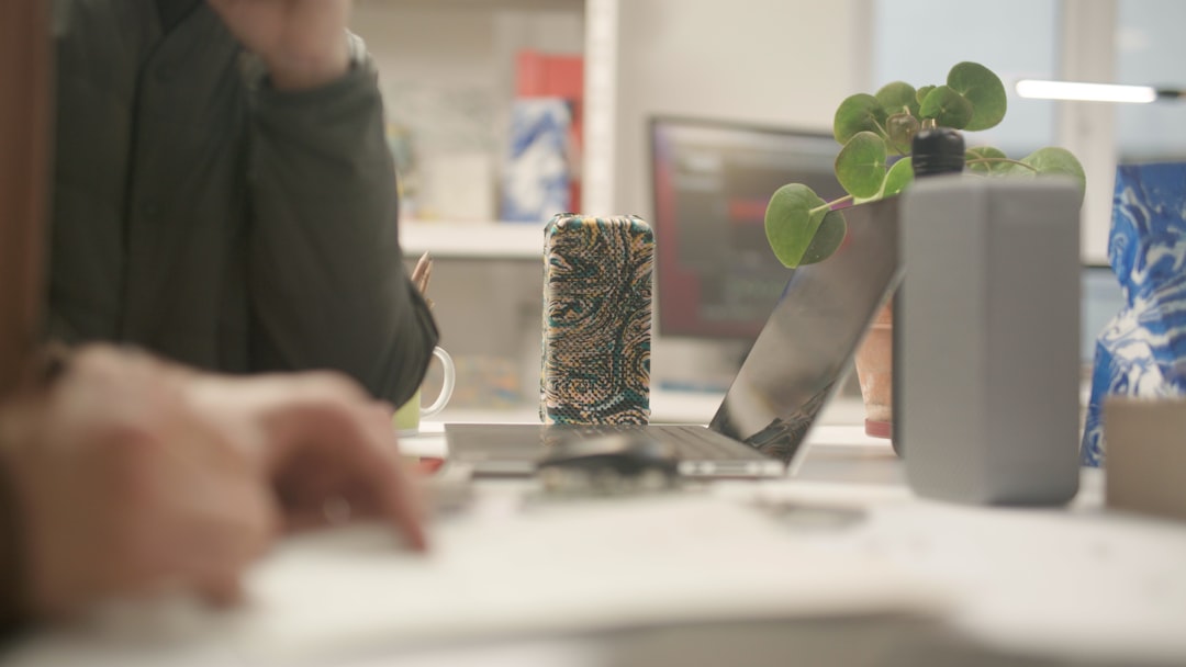 Photographer and web designer comparing product photo crops and web mockups on a bright studio table