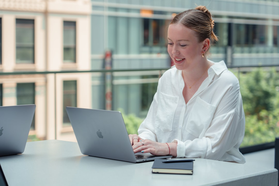 Researcher reviewing AI-assisted notes beside printed source pages and a laptop in a bright office