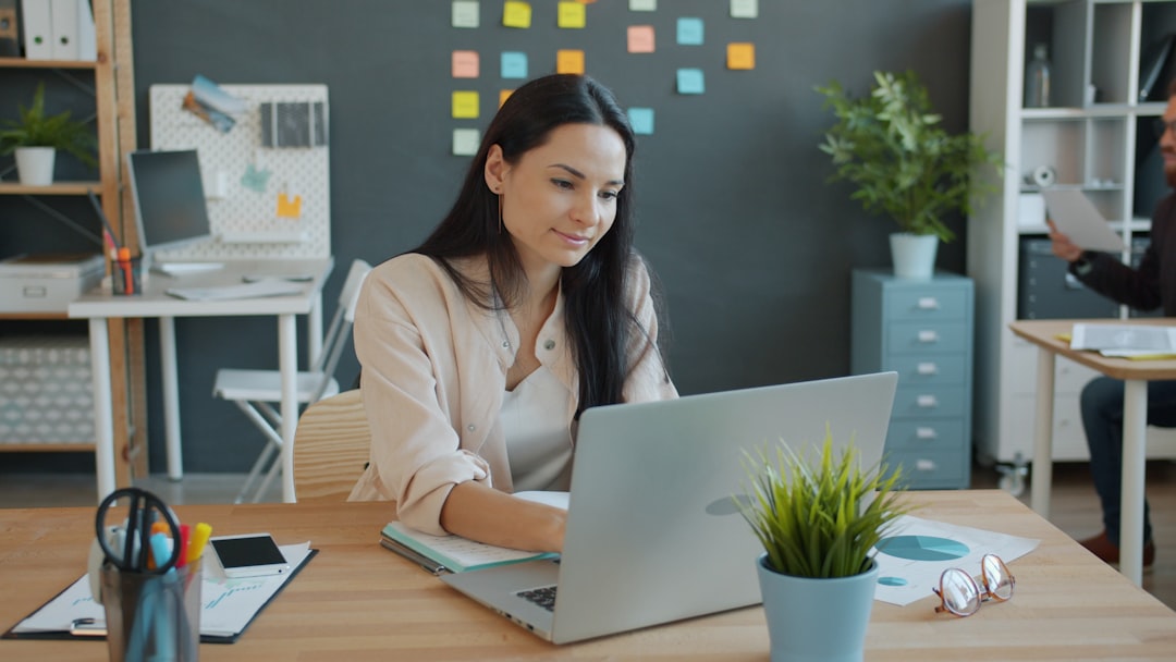 A person reviewing software options on a laptop at a tidy desktop workspace