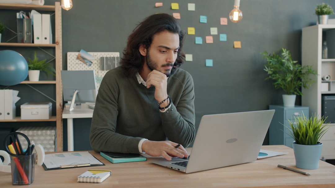 A developer reviewing code on a laptop in a clean workspace