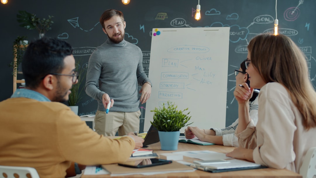Team reviewing support chatbot workflows on laptops and a whiteboard