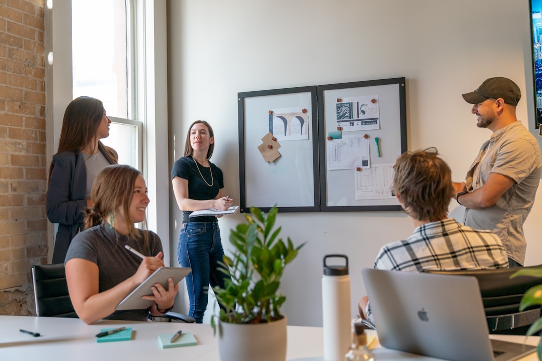 Small team collaborating at a desk while an AI-assisted coding workflow builds a web prototype