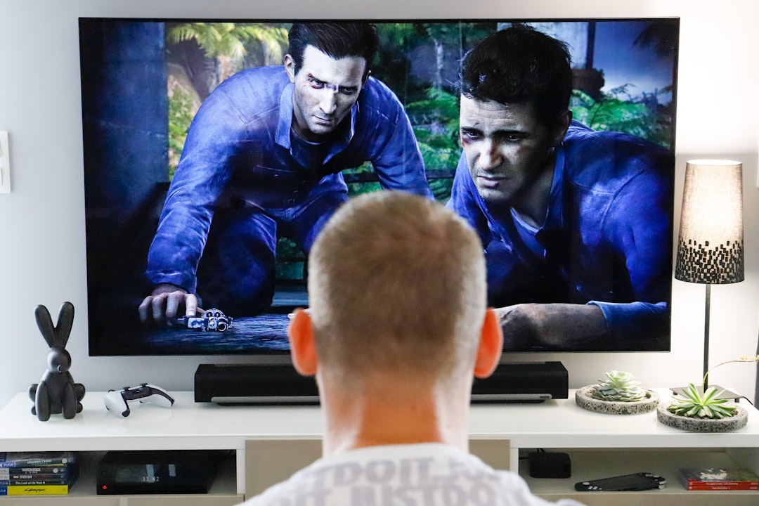 Person comparing console models on a living room table after a price update