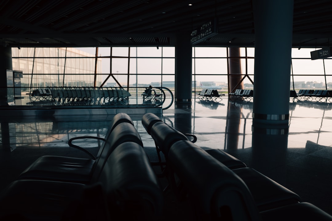 Cordless travel vacuum compression bags and a compact pump beside an open carry-on suitcase