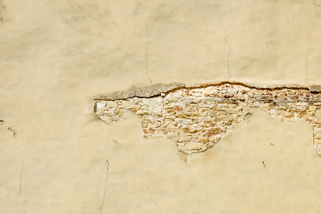 Small drywall patch kit and putty knife set beside a clean wall with a tiny repaired mark.