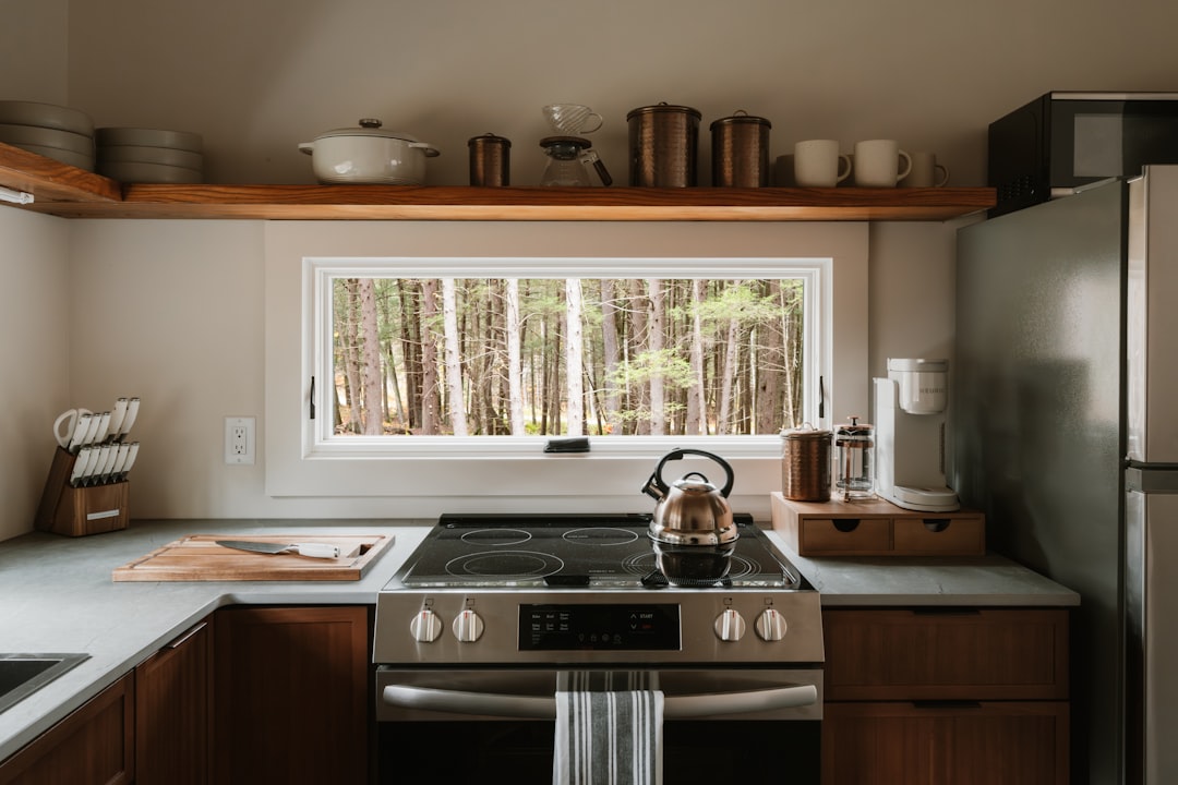 Compact countertop dishwasher on a small kitchen counter with dishes nearby.