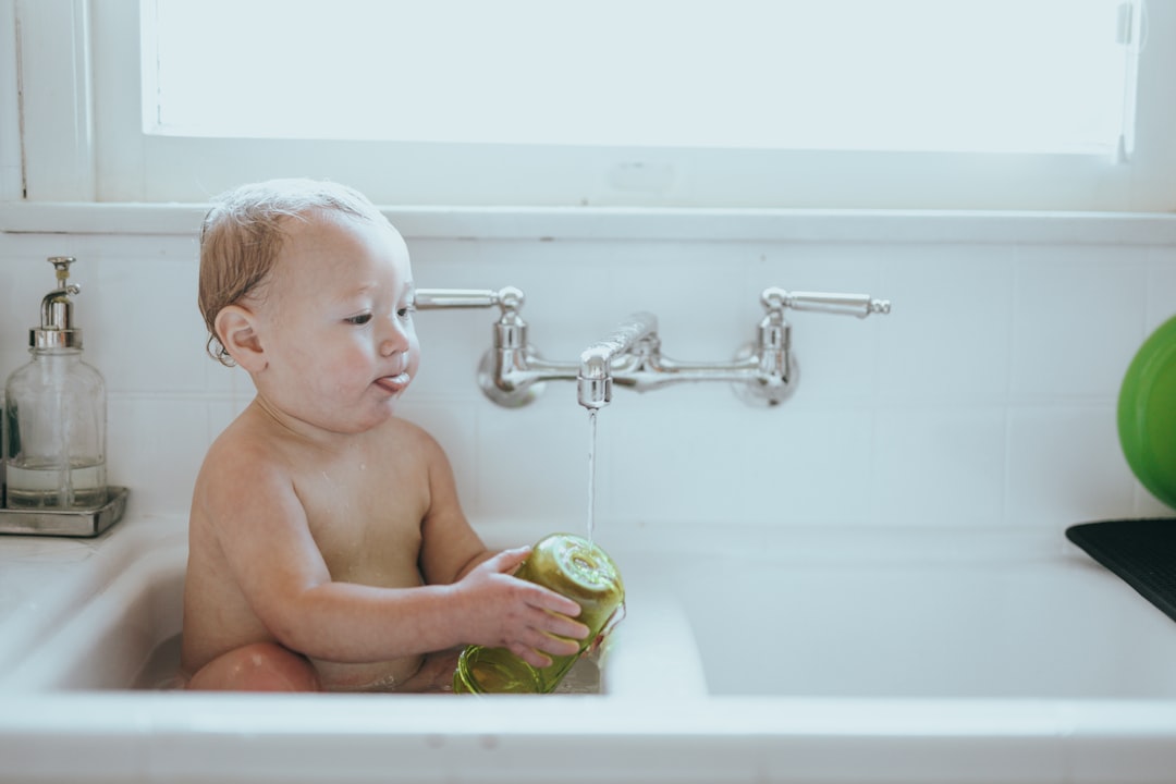 Modern baby bottle washer set up on a clean kitchen counter with bottles and pump parts nearby.