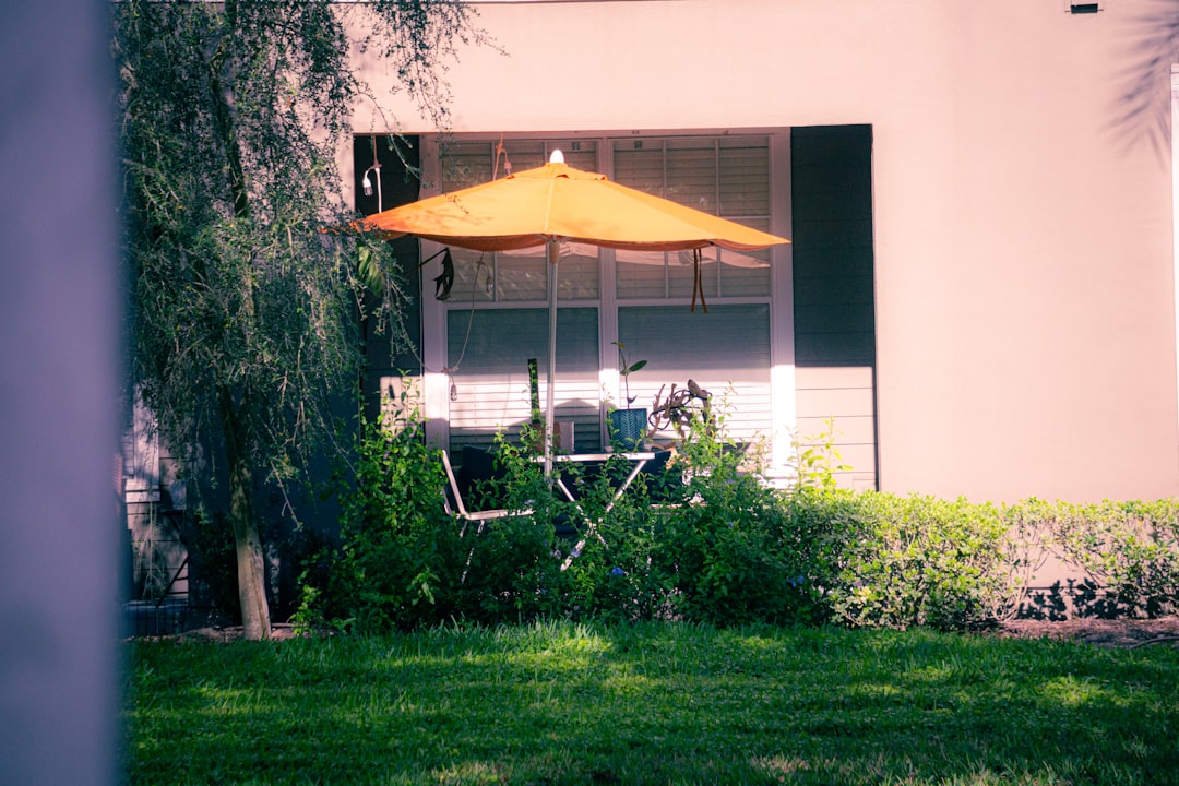 Large 15-foot patio umbrella casting shade over a backyard dining area