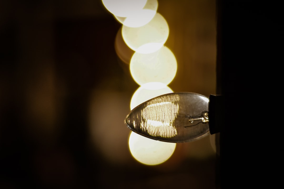 Four rechargeable emergency light bulbs arranged with simple storm prep supplies on a kitchen counter.
