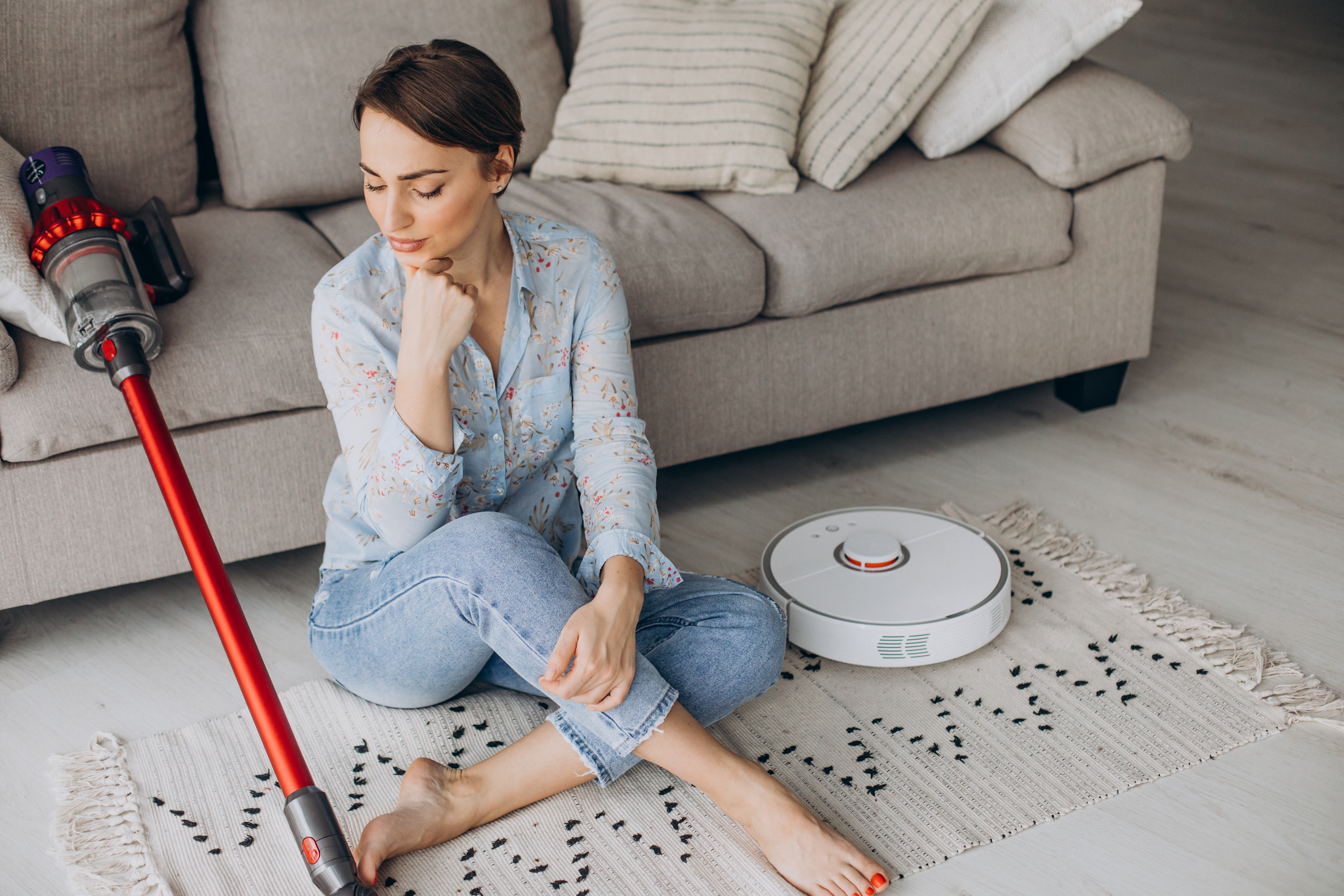 Cordless vacuum ready for a quick living room cleanup near a rug and hardwood floor.