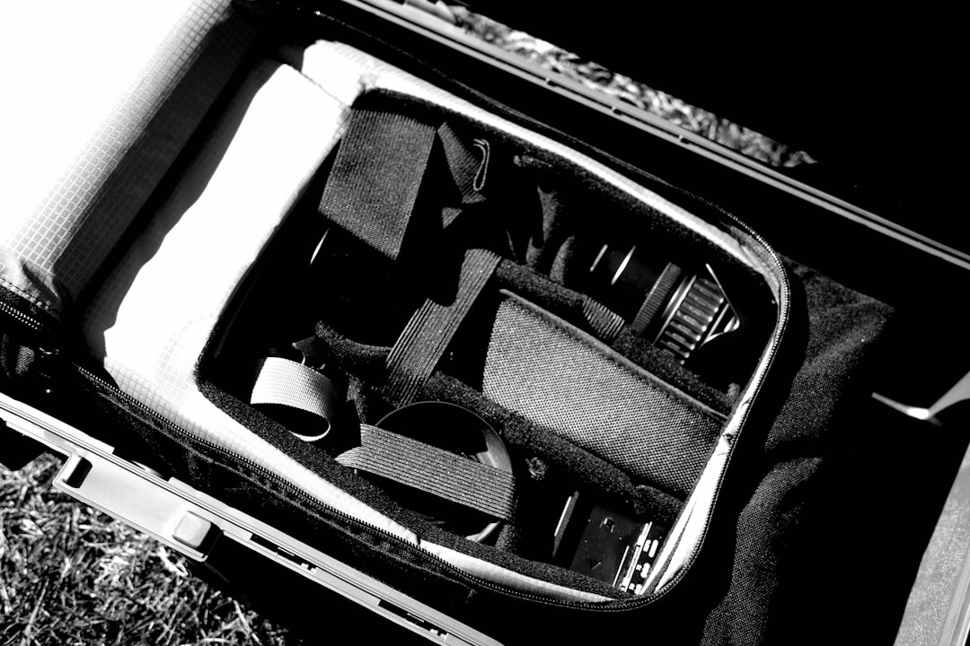 Cordless travel vacuum compression bags and folded clothes arranged beside an open suitcase.