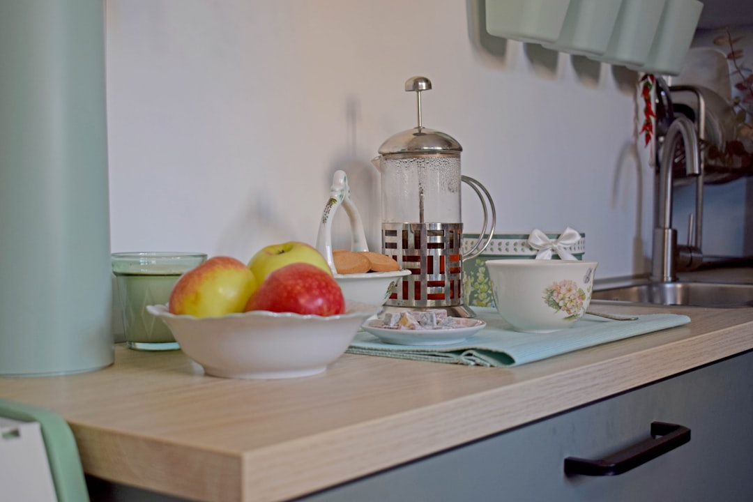 Counter with kettle and milk frother, two mugs, and cocoa ingredients ready for service