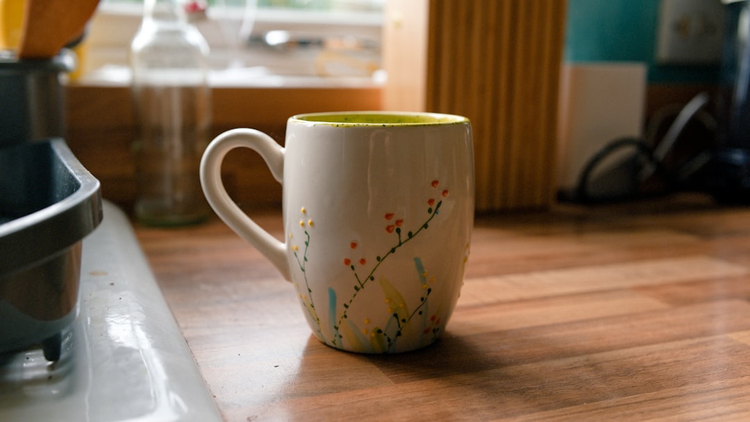 A small kitchen counter with a kettle, milk frother, and serving tray ready for tea and hot cocoa