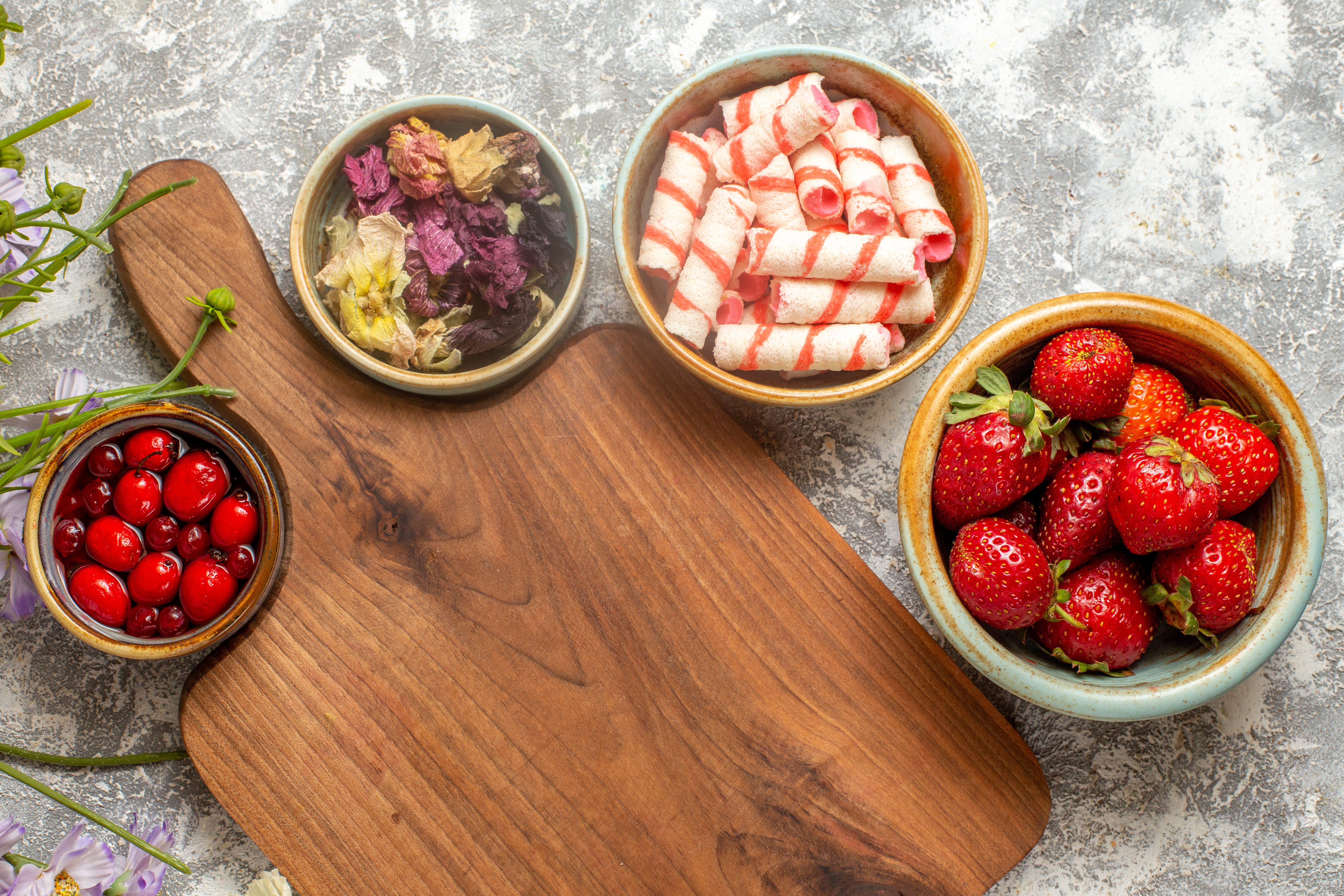 A chocolate fondue dessert board with fruit, marshmallows, and an electric melting pot on a kitchen counter