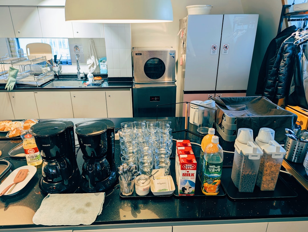 Compact counter countertop station with kettle, milk frother, and hot cocoa setup in warm morning-to-evening lighting