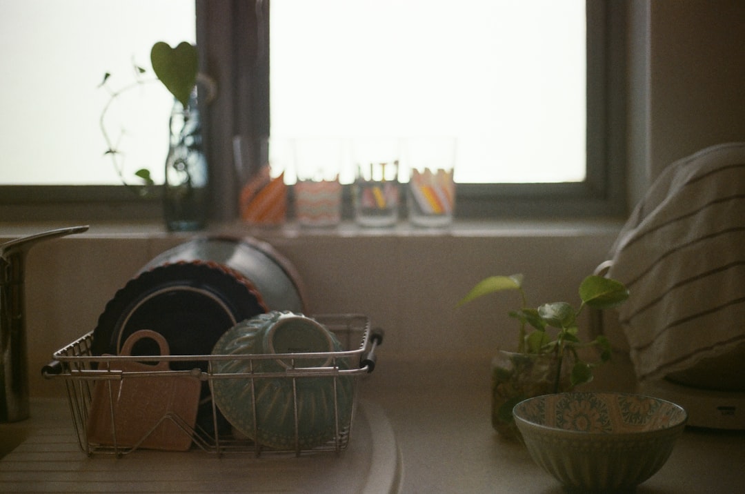 Evening kitchen counter set with kettles, a milk frother, and tea and cocoa mugs ready to serve