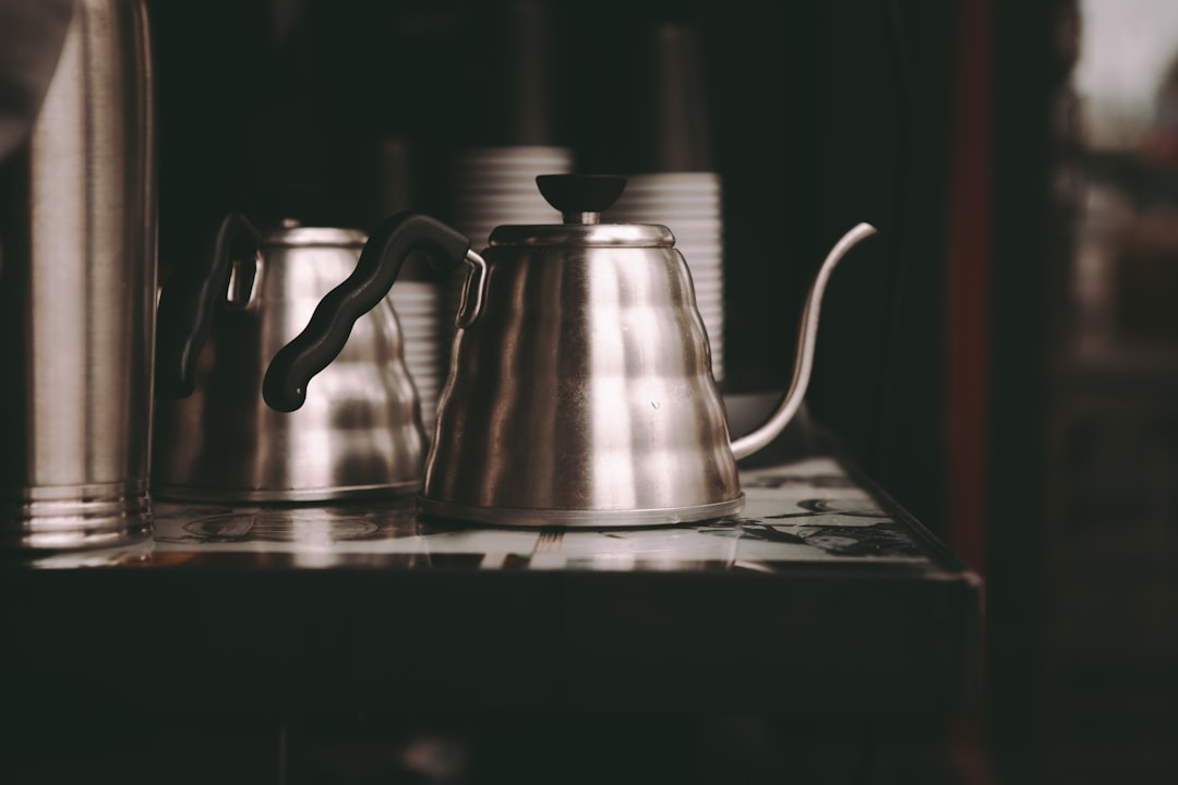 Clean countertop with milk frother, kettle, and cocoa ingredients in a tidy drink station