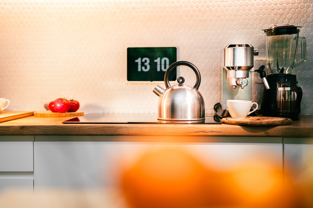 A compact counter with a gooseneck kettle and compact milk frother ready for serving espresso and cocoa