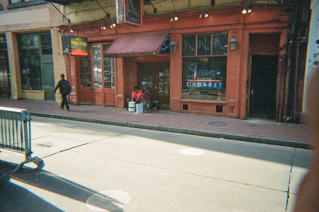 Shop owner checking local profile details on a tablet by storefront entrance.