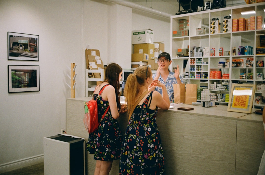 Two small-business staff review a suspicious payment request at a counter with a checklist